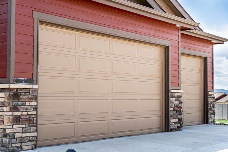 Red house with tan garage doors