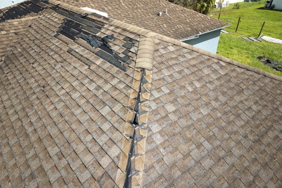 Damaged house roof with missing shingles after hurricane Ian in Florida. Consequences of natural disaster